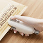 White mini bag sealer held in hand, pressing onto an open food bag for sealing.