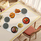 Rotating serving tray with round dark plates holding assorted appetizers at table