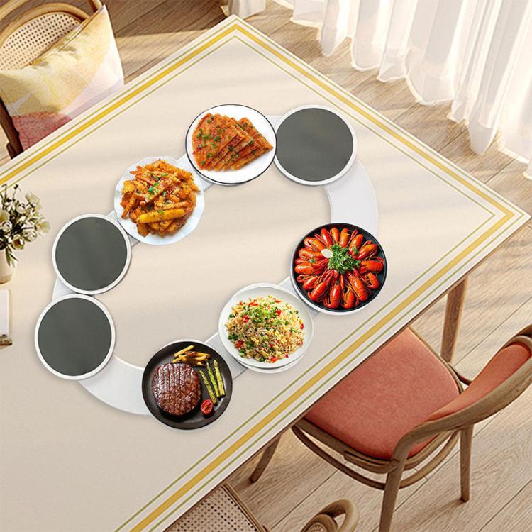 Rotating serving tray with round dark plates holding assorted appetizers at table