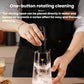 Black handheld milk frother in a clear cup, showing rotating whisk cleaning motion.
