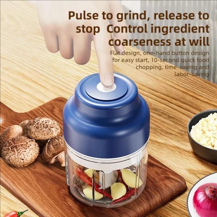 Blue electric mini chopper on wood board with clear cup and stainless blade insert