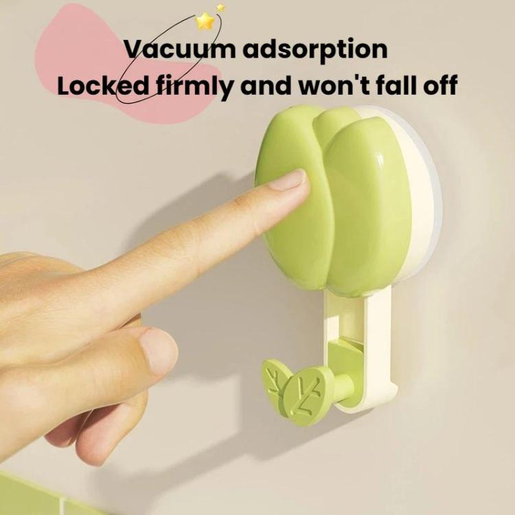 Hand pressing a green flower suction cup towel rack to the wall mount
