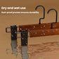 Wooden pants hanger with black metal clamps and curved hanging hooks