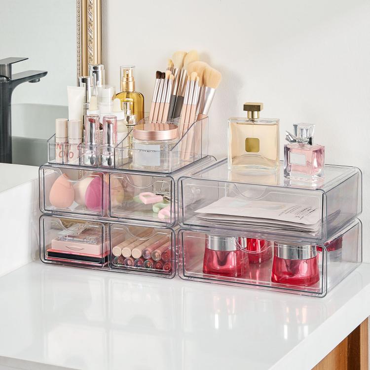 Clear acrylic desktop makeup organizer with stacked drawers and open top compartments