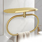 Gold stainless steel towel ring with oval shelf holding a folded towel.