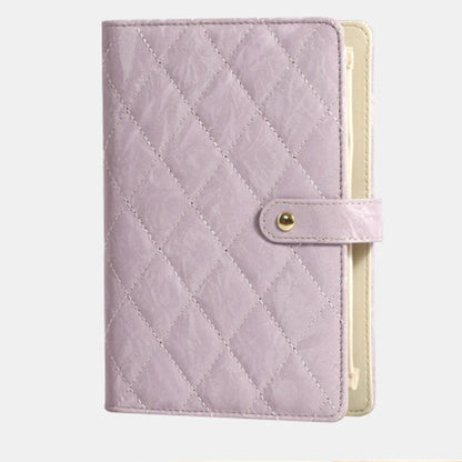 Lavender quilted jewelry organizer book with snap strap and cream interior backing.