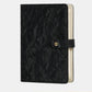 Black quilted jewelry organizer book with snap front strap and beige interior backing.