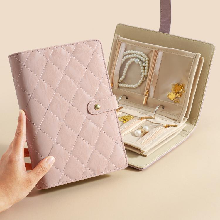 Lavender and beige jewelry organizer book opened with multiple padded compartments for jewelry.