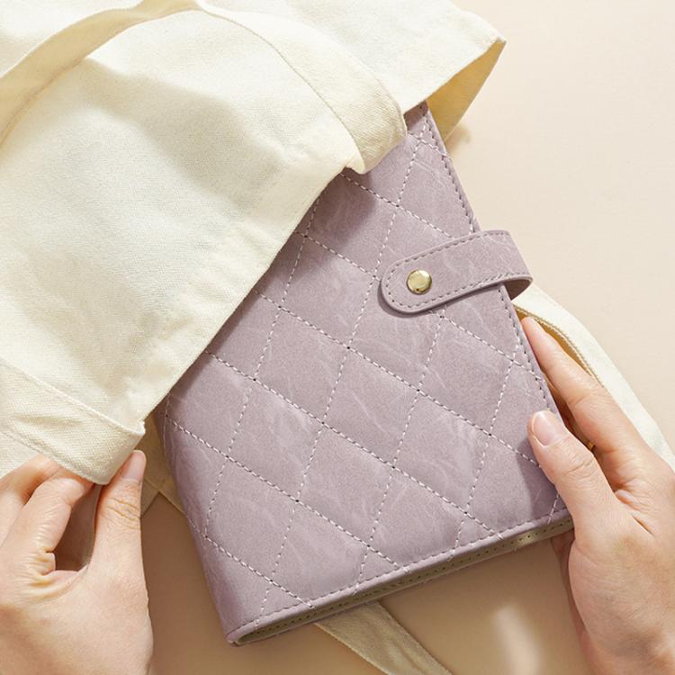 Purple quilted jewelry organizer book with button strap and hinged cover