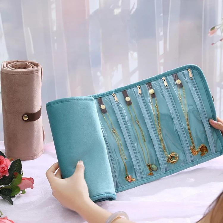 Turquoise roll-up jewelry organizer bag open flat with elastic loops and necklace slots