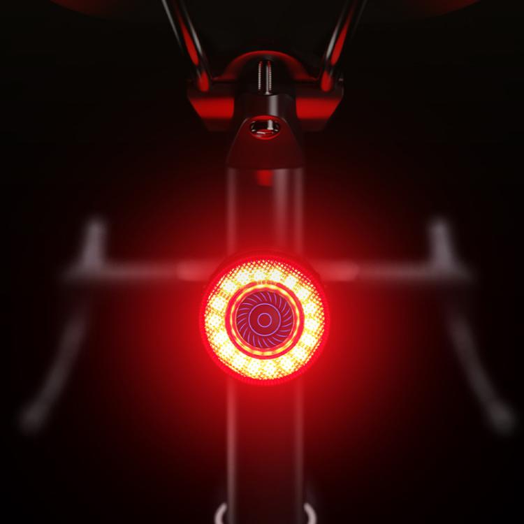 Bicycle rear light glowing red with bright circular LED pattern