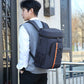 Insulated backpack cooler on model, navy-gray with front pocket, black straps, orange trim