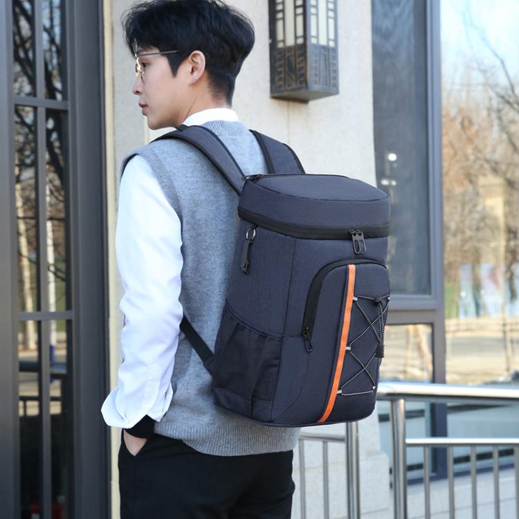 Insulated backpack cooler on model, navy-gray with front pocket, black straps, orange trim