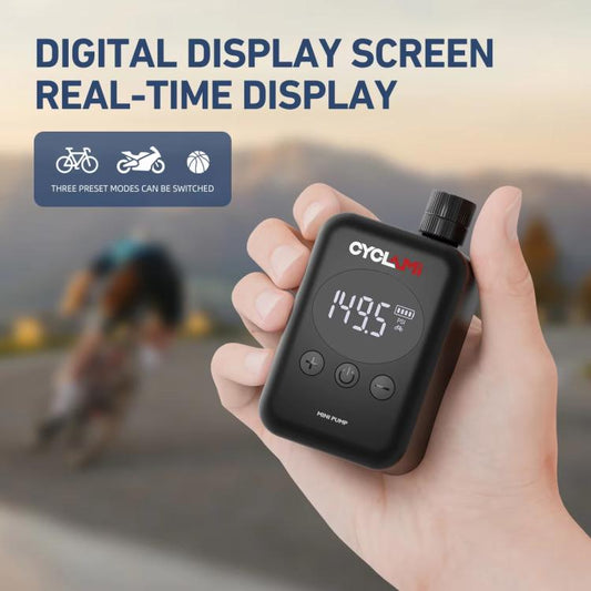 Electric air pump with digital display held in hand, black, for bike tire inflation.