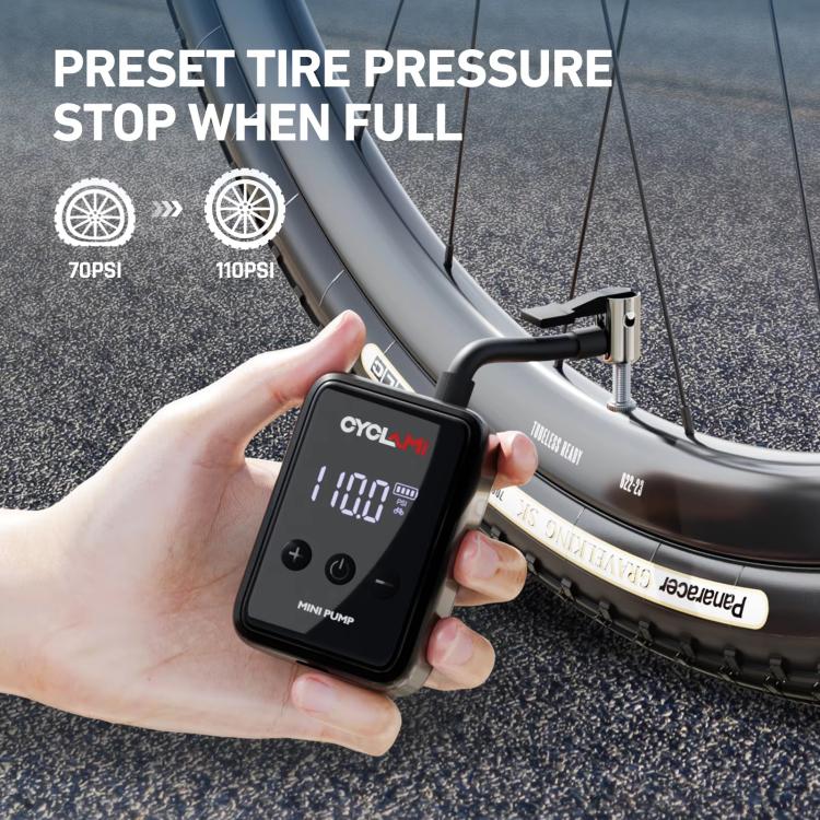 Hand using compact portable air pump on a bicycle tire, digital pressure display
