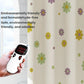 White shower curtain with colorful flower print, near a hand-held thermometer device