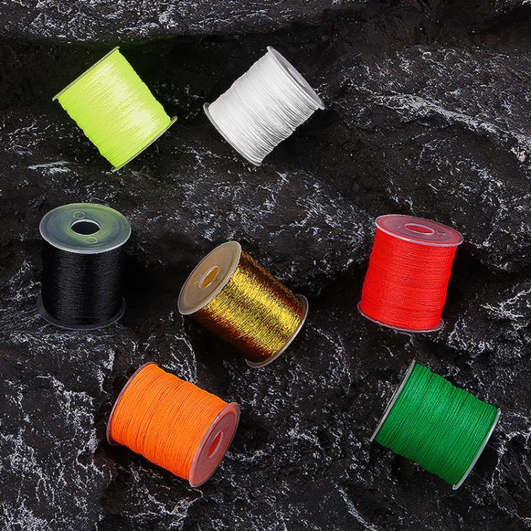 Color assortment of fishing rod tying line spools on a dark stone surface
