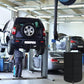 Black tire cover tarp placed over a car tire in an auto workshop setting