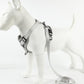 Gray dog vest harness with adjustable straps and metal buckles, leash attached
