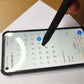 Multifunctional stylus tool pen tapping a smartphone screen with the pen tip