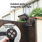 Outdoor solar wall light with magnetic base, mounted on a wall