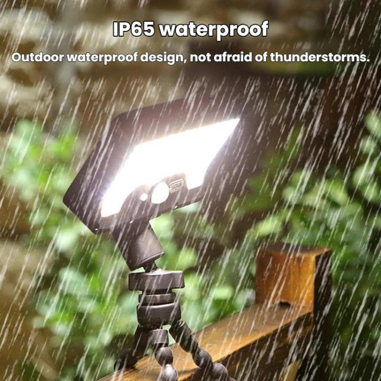 Black outdoor solar motion sensor light shown in rain, octopus-style tripod legs
