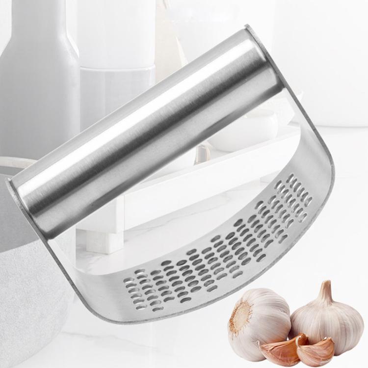 Stainless steel curved garlic press with perforated base and garlic cloves