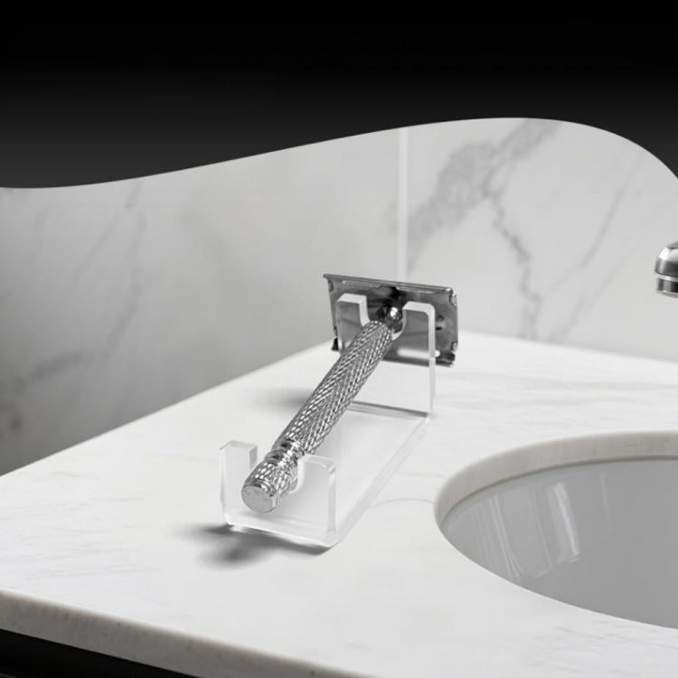 Clear acrylic shaver holder standing on bathroom countertop beside the basin