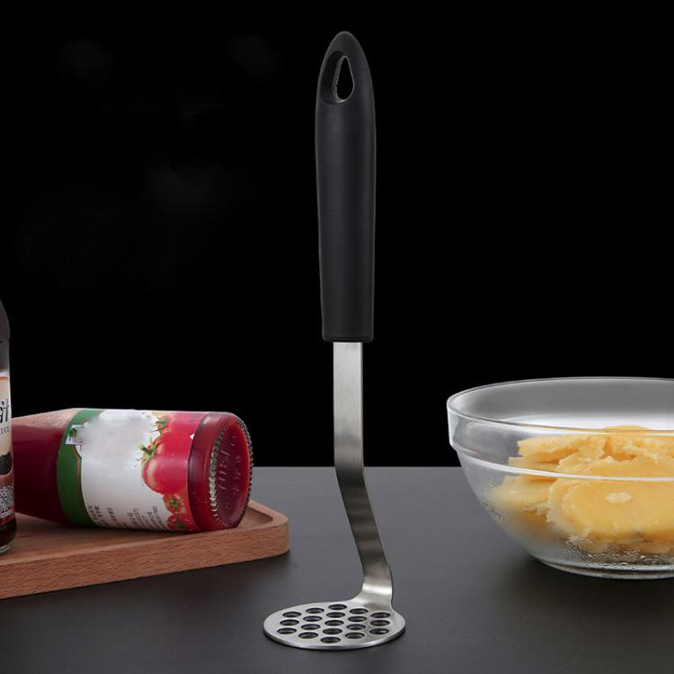 Potato masher with perforated stainless steel disc head and black silicone handle.