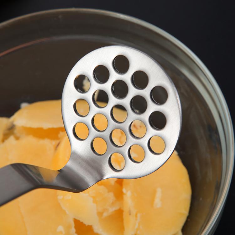 Potato masher disc presses potatoes inside a bowl, with perforated stainless head.