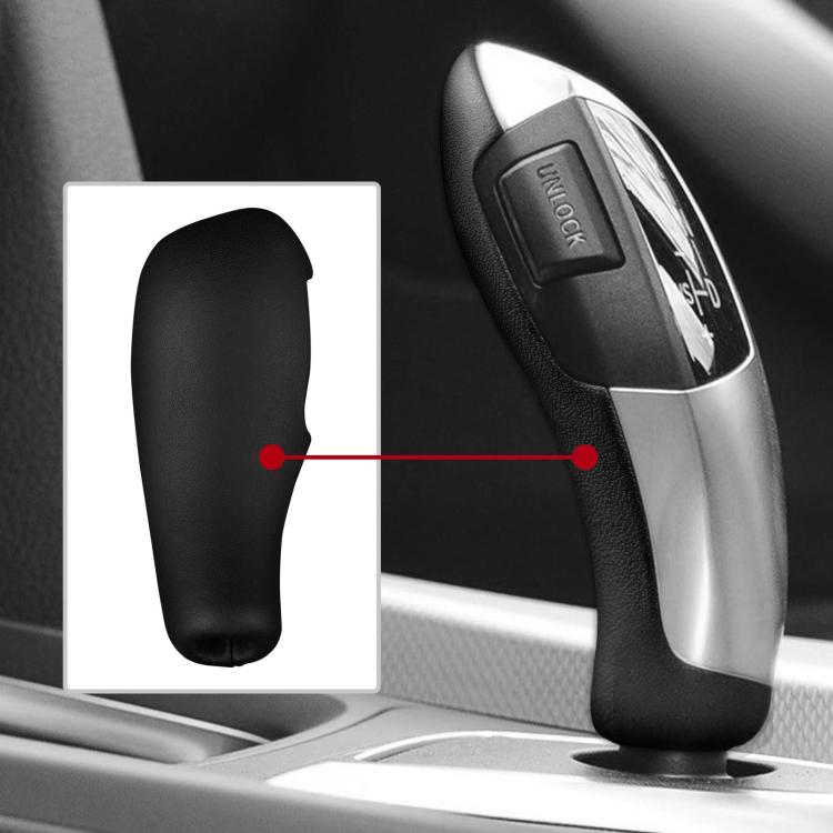 Black gear shift knob cover fitted on a car shift lever with silver trim.
