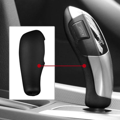 Black gear shift knob cover fitted on a car shift lever with silver trim.