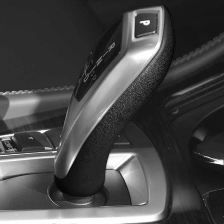 Black gear shift knob cover installed on car console near the shift area.
