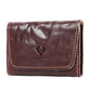 Brown leather credit card wallet with front flap, tan stitching, and embossed logo.