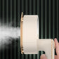 White garment steamer with steam outlet side view and user holding handle