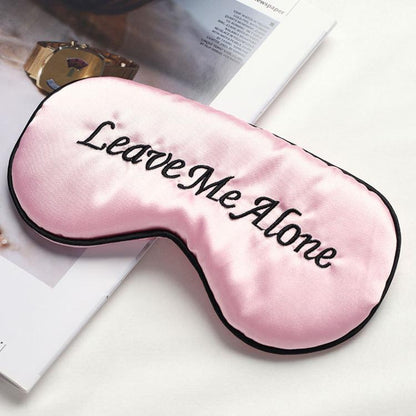 Pink satin sleep mask with “Leave Me Alone” embroidery and black trim
