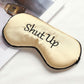 Champagne satin sleep mask with “Shut Up” embroidery and black border