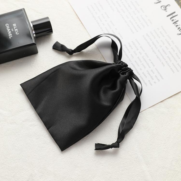 Black satin drawstring pouch for small jewelry, with tie cords and gathered top.