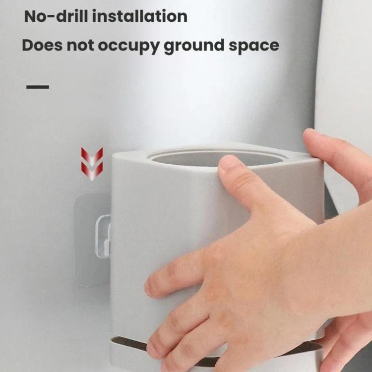 Wall-mounted toilet brush holder with gray base and handle installation by hand
