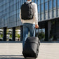 Black rolling travel backpack on wheels with top handle and side pockets