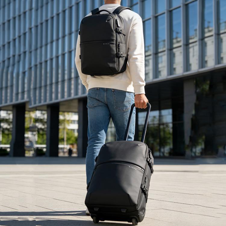 Black rolling travel backpack on wheels with top handle and side pockets
