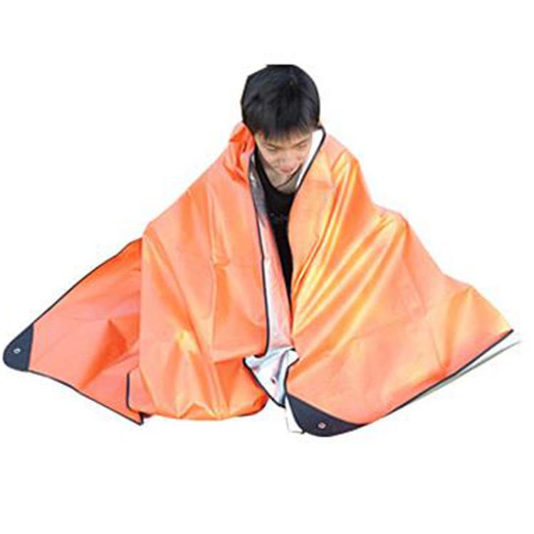 Orange emergency blanket tarp with dark edge, wrapped around a seated person