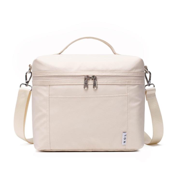 Light beige insulated lunch bag with top handle, front zipper, and side shoulder straps