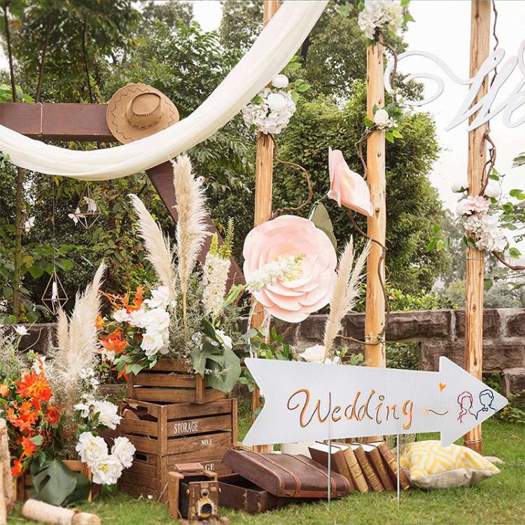 White wedding arrow yard sign on two stakes with 'Wedding' lettering