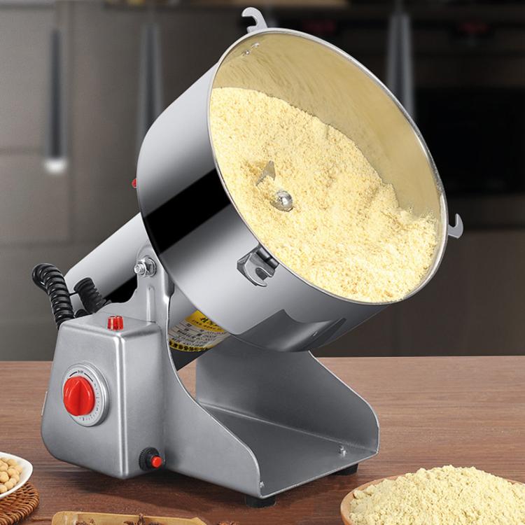 Stainless steel grain grinder with open hopper releasing light powder