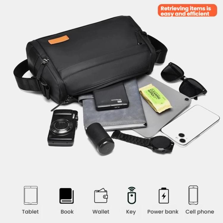 Black crossbody bag laid out with small carry items including phone and wallet