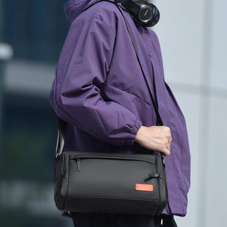 Black crossbody bag with front zipper pocket and adjustable shoulder strap, small rectangular.