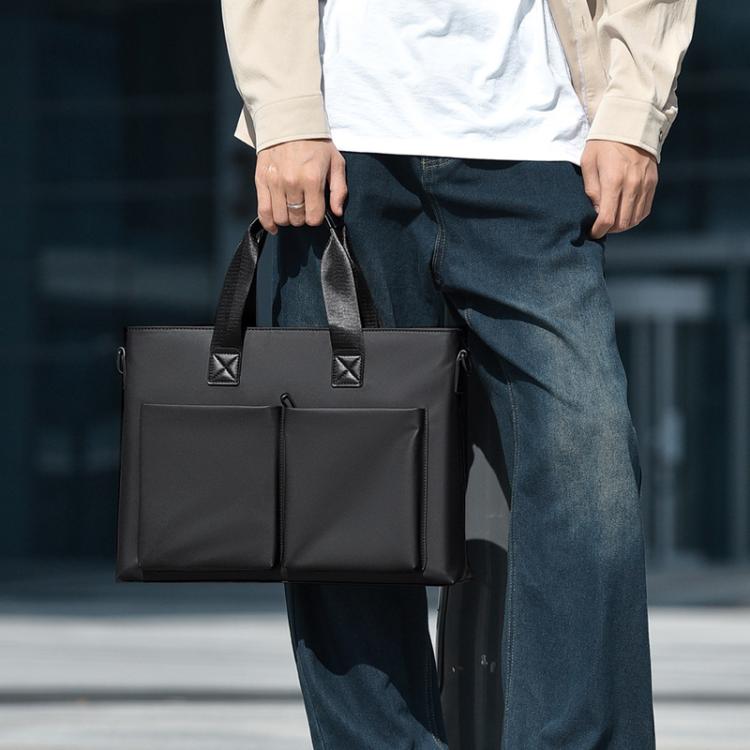 Men's waterproof laptop messenger bag in black carried in hand with front dual pockets