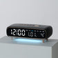 Black digital alarm clock with date, weekday, temperature, and time display on front