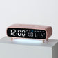 Pink digital alarm clock with date, weekday, temperature, and time display on front